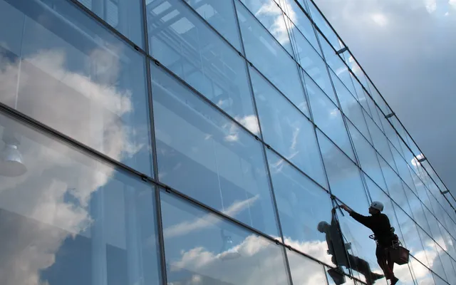 Window cleaner working on large glass facade