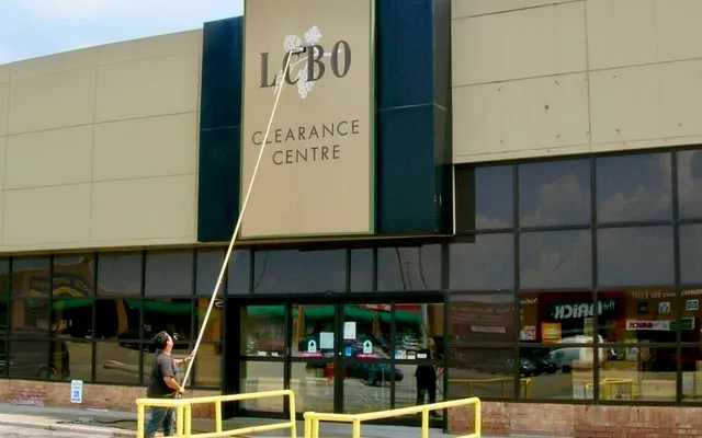 Cleaning a sign and windows at an LCBO in Toronto