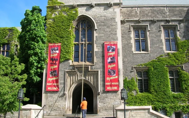 Hart House with ivy-covered walls under clear sky