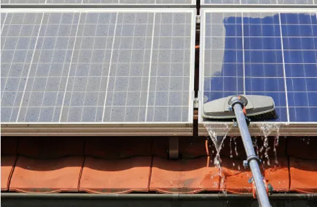 Robot cleaning solar panels on a rooftop