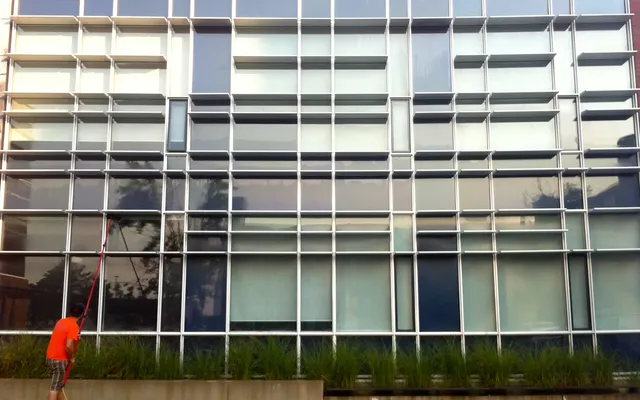 Man cleaning large modern building windows