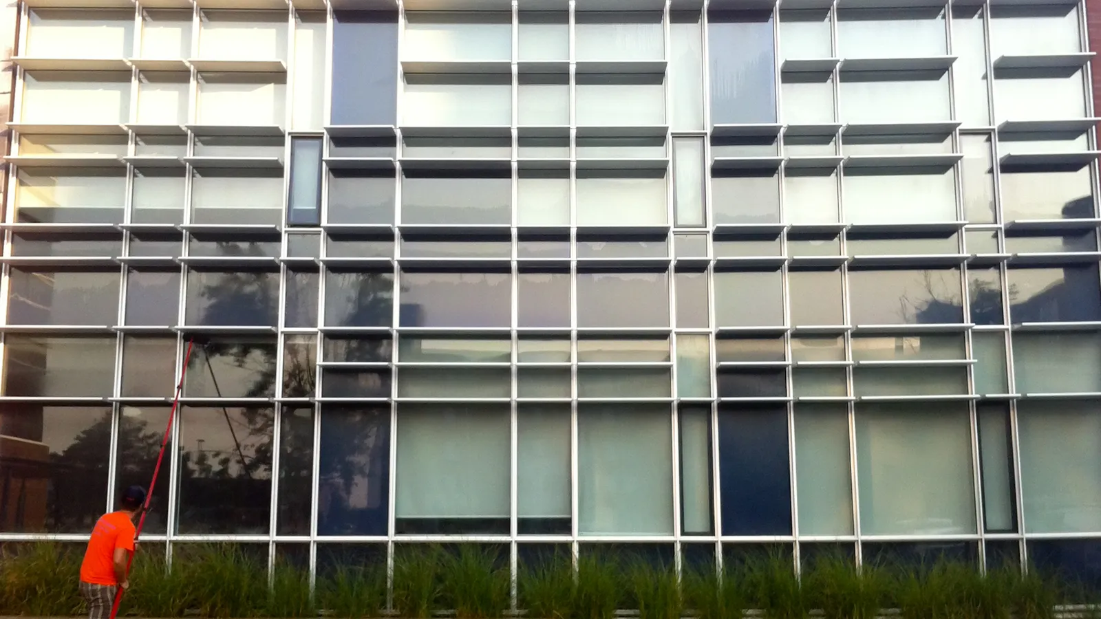 Man cleaning large modern building windows