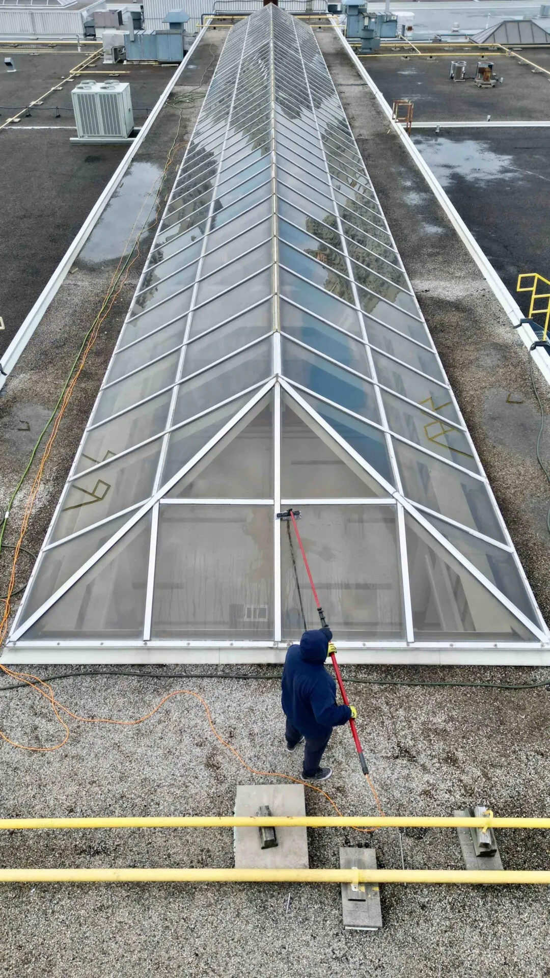 Worker cleaning rooftop greenhouse structure