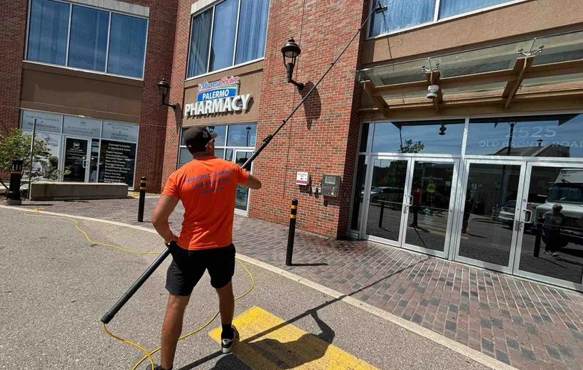 SKYPOLE technician using a water-fed pole to clean exterior windows at 2525 Old Bronte Road in Oakville