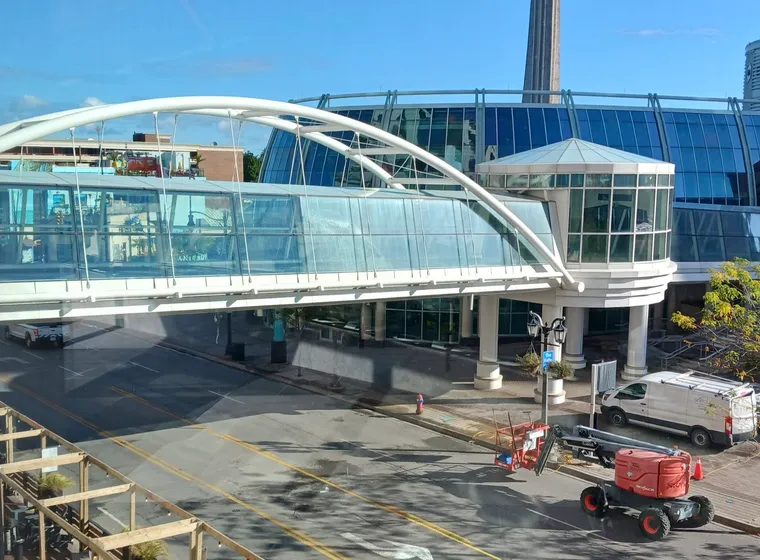 Modern pedestrian bridge over city street and construction. Before and after window clean
