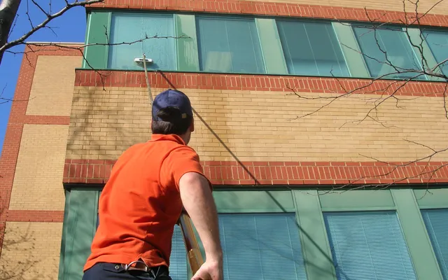 Man cleaning windows on tall building exterior