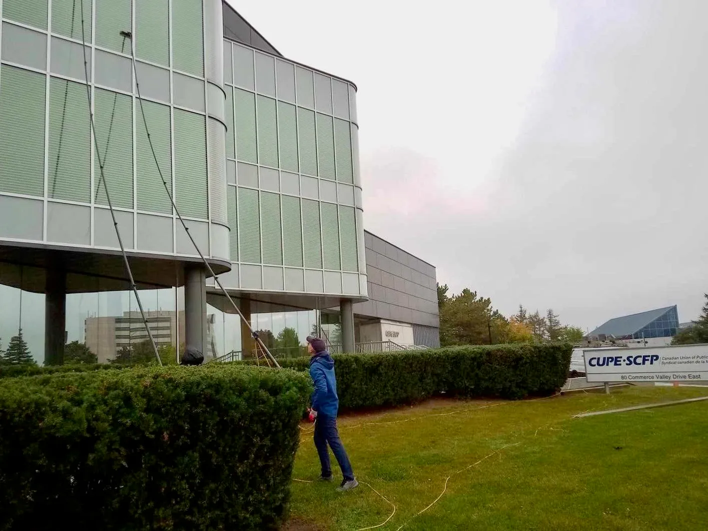 Person washing windows of a modern glass building