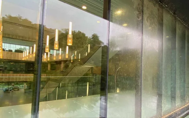 Professional commercial window cleaning in Toronto by SKYPOLE on a modern business building with reflective glass windows and clear blue skies.
