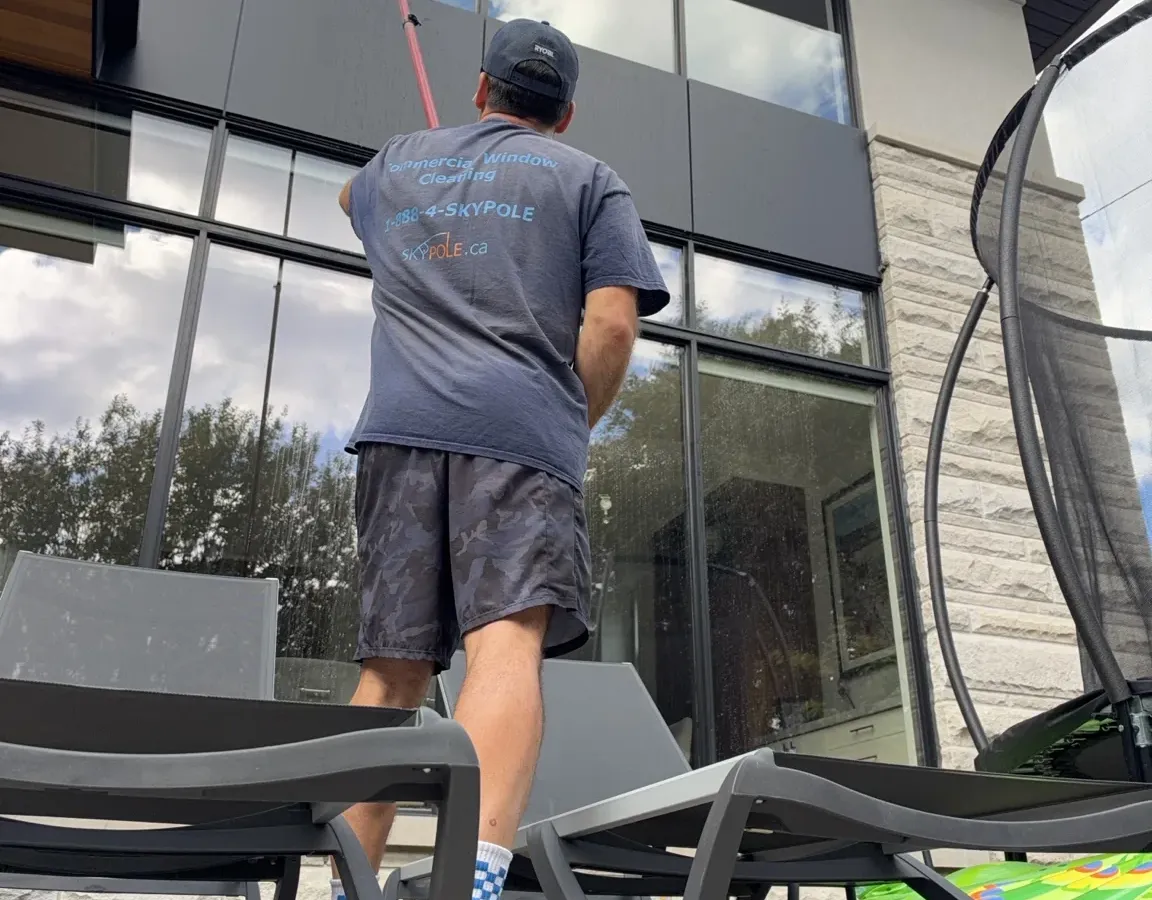 SKYPOLE technician cleaning upper-storey windows with a water-fed pole at a home in Islington–City Centre West, Etobicoke.