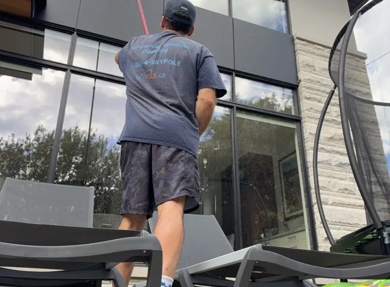 SKYPOLE technician cleaning upper-storey windows with a water-fed pole at a home in Islington–City Centre West, Etobicoke.
