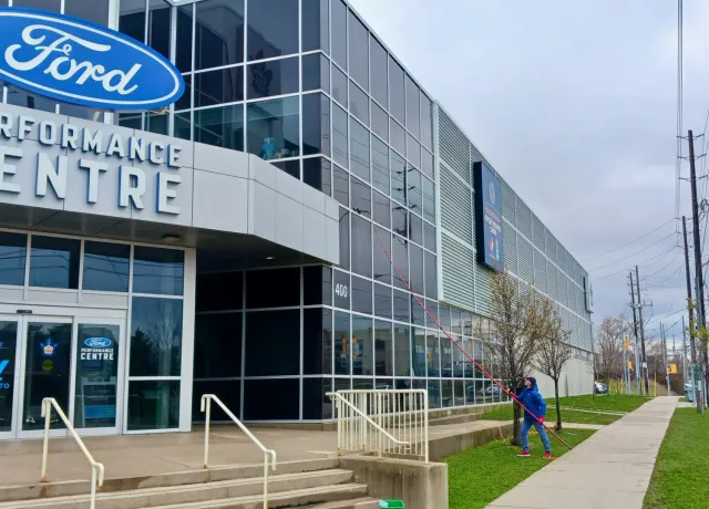 Ford Performance Centre exterior with signage and passerby.