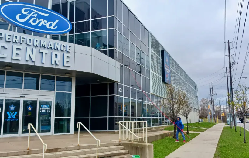 Ford Performance Centre exterior with signage and passerby.