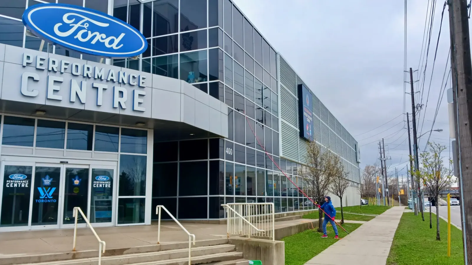 Ford Performance Centre exterior with signage and passerby.