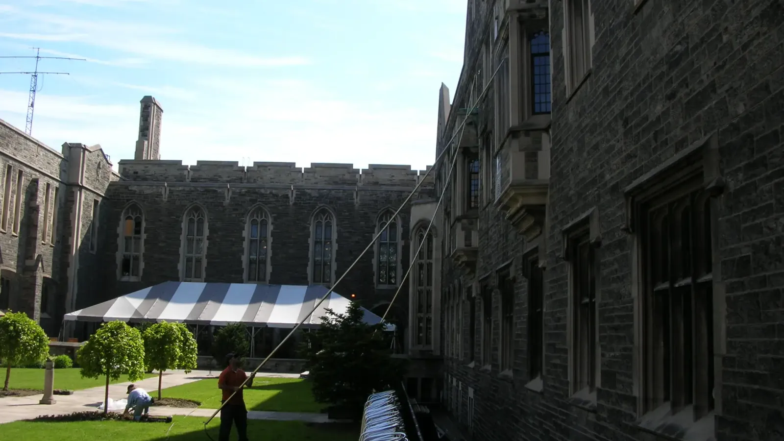 Historic university building with workers in courtyard.