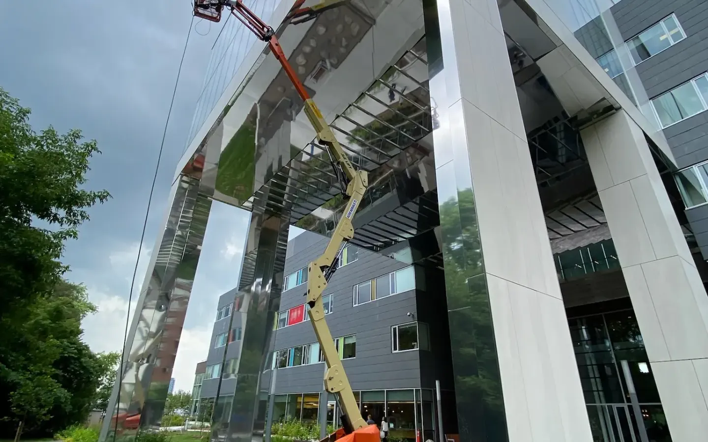 Cherry picker crane at modern glass building.