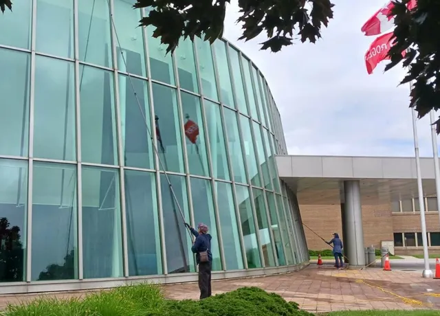 Workers cleaning glass facade of a modern building