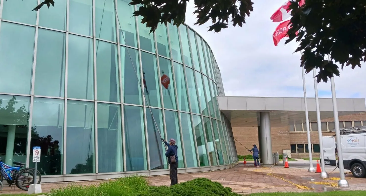 Workers cleaning glass facade of a modern building