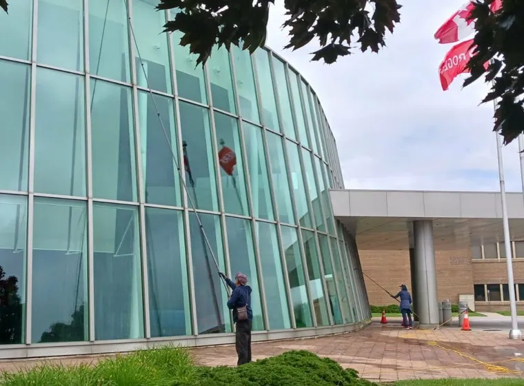 Workers cleaning glass facade of a modern building