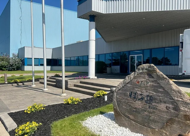 Industrial building entrance with landscaped garden and signage rock