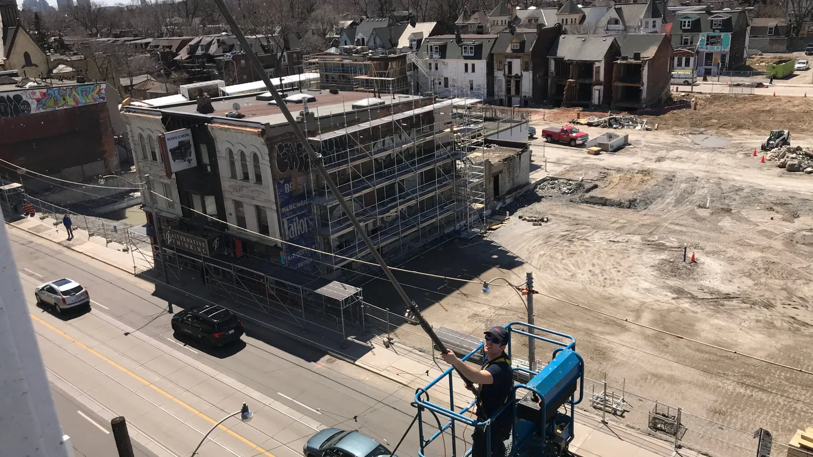 Urban construction site with worker in elevated platform