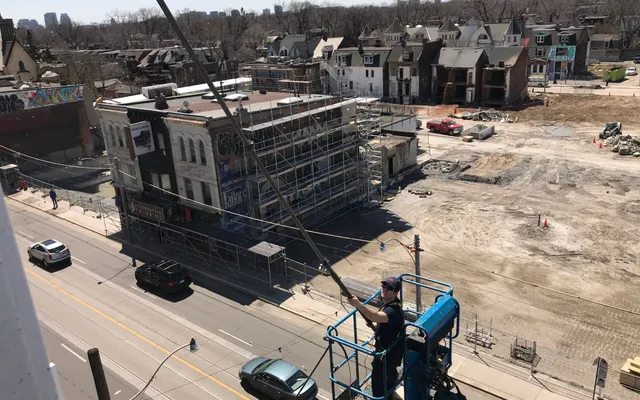 Urban construction site with worker in elevated platform