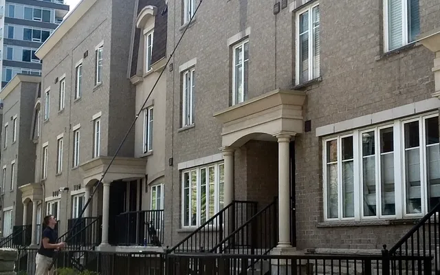 Man power washing modern townhouse exterior