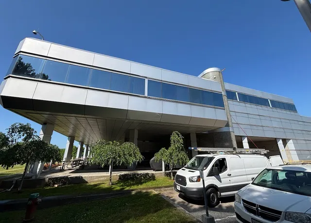 Modern elevated building with parked vehicles underneath