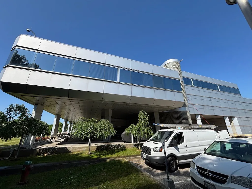 Modern elevated building with parked vehicles underneath