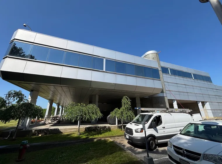 Modern elevated building with parked vehicles underneath