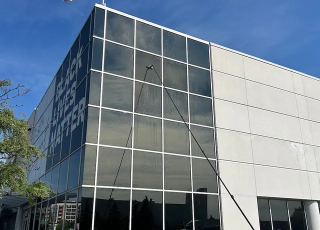 Man washing windows, airplane flying over building