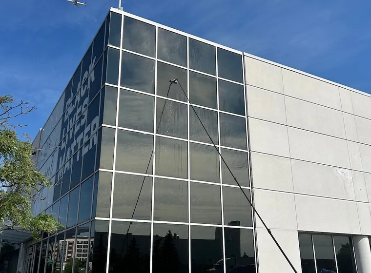Man washing windows, airplane flying over building