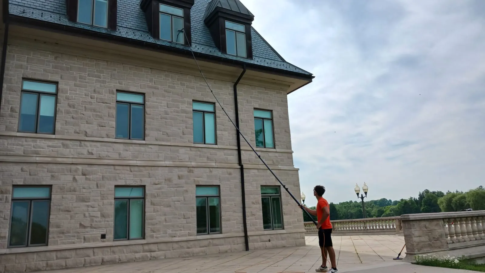 Man cleaning windows of large stone building