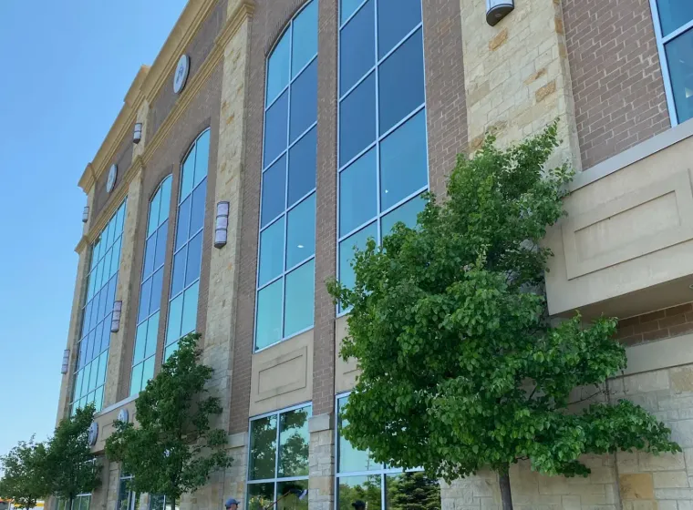 Person power-washing Lifetime Fitness entrance.