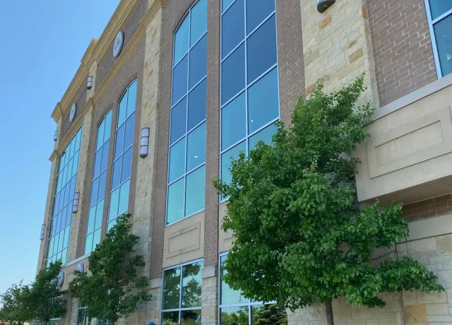 Person power-washing Lifetime Fitness entrance.