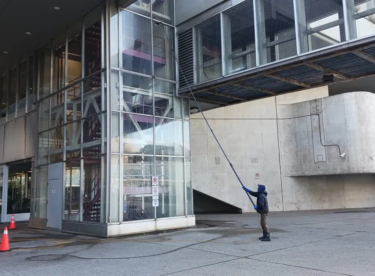 Person cleaning windows on modern building facade