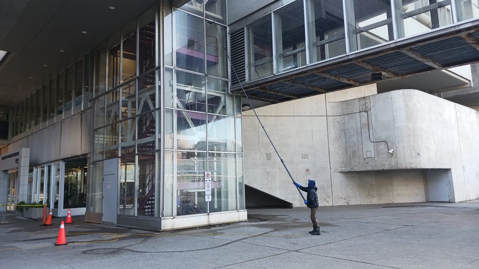 Person cleaning windows on modern building facade