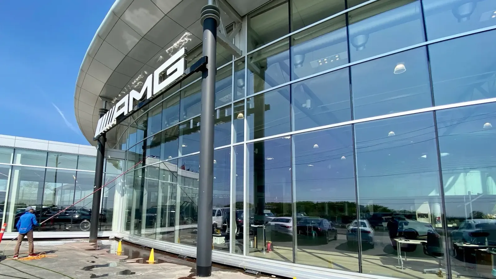 AMG dealership exterior with worker washing windows.