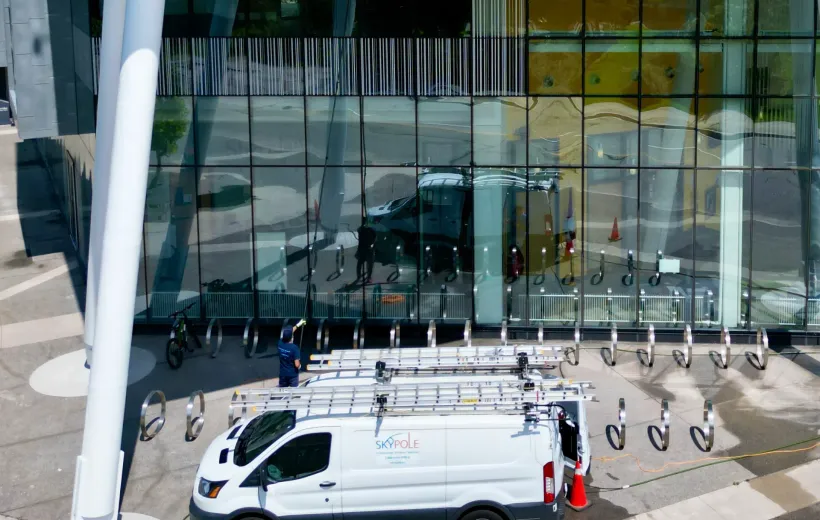 Van parked outside modern glass building with bike racks