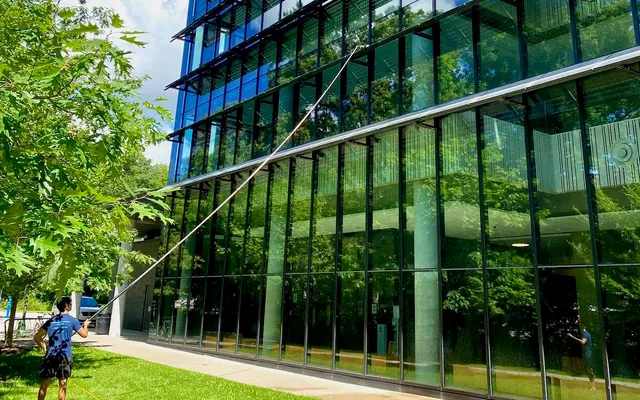 Man cleaning large glass facade of modern building