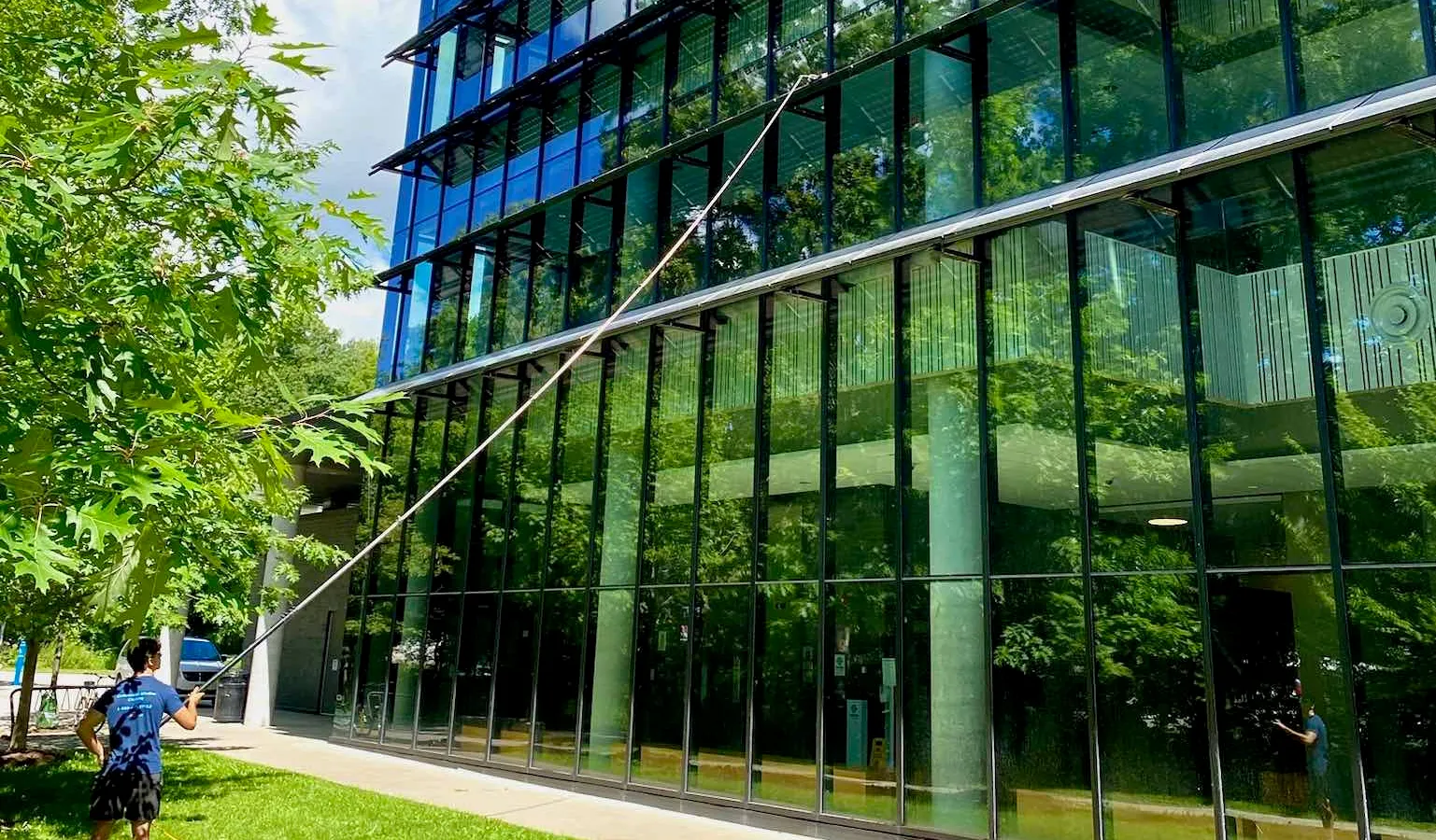 Man cleaning large glass facade of modern building