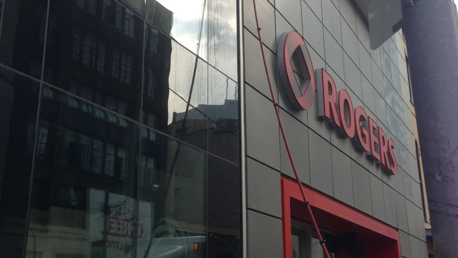 Man cleaning window at urban Rogers store facade in Toronto