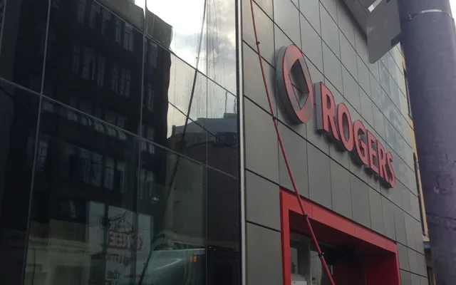 Man cleaning window at urban Rogers store facade in Toronto