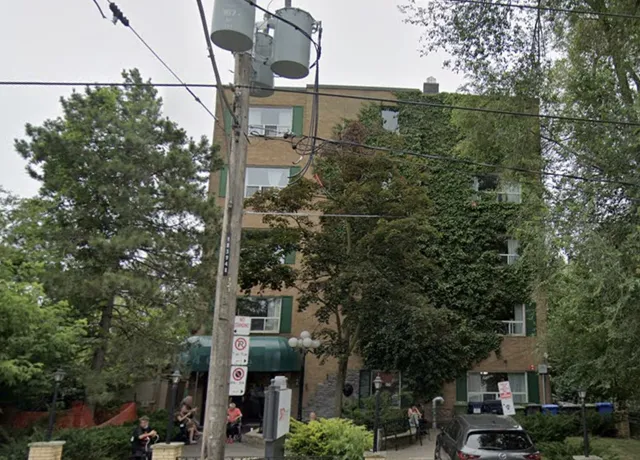 Urban street scene with apartment building and parked cars