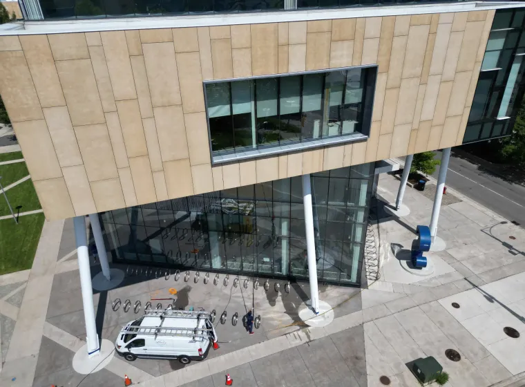 Aerial view of modern building with glass facade and parked van.