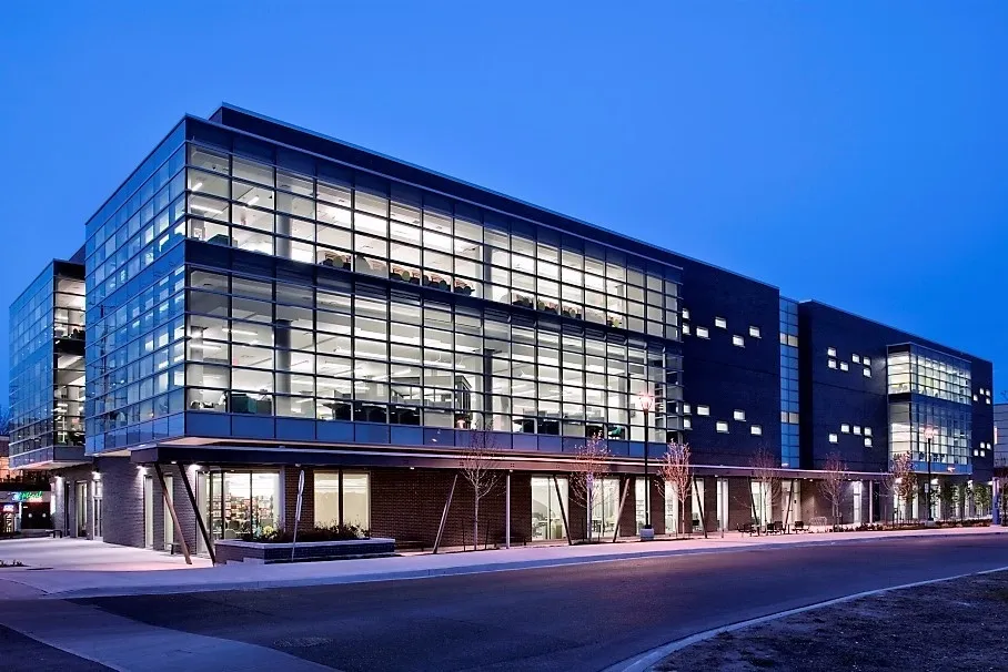 Modern glass facade office building illuminated at dusk