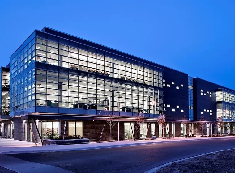 Modern glass facade office building illuminated at dusk