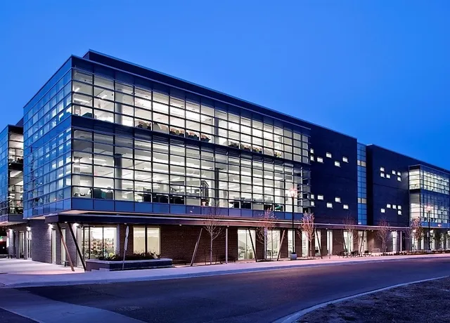 Modern glass facade office building illuminated at dusk