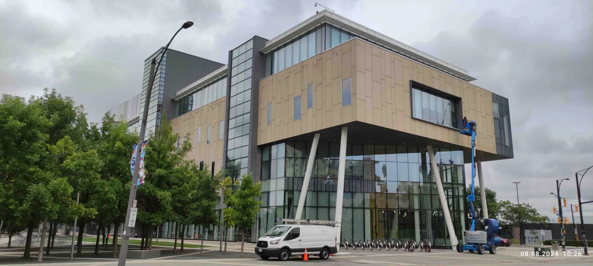 Modern building exterior with worker on lift cleaning windows
