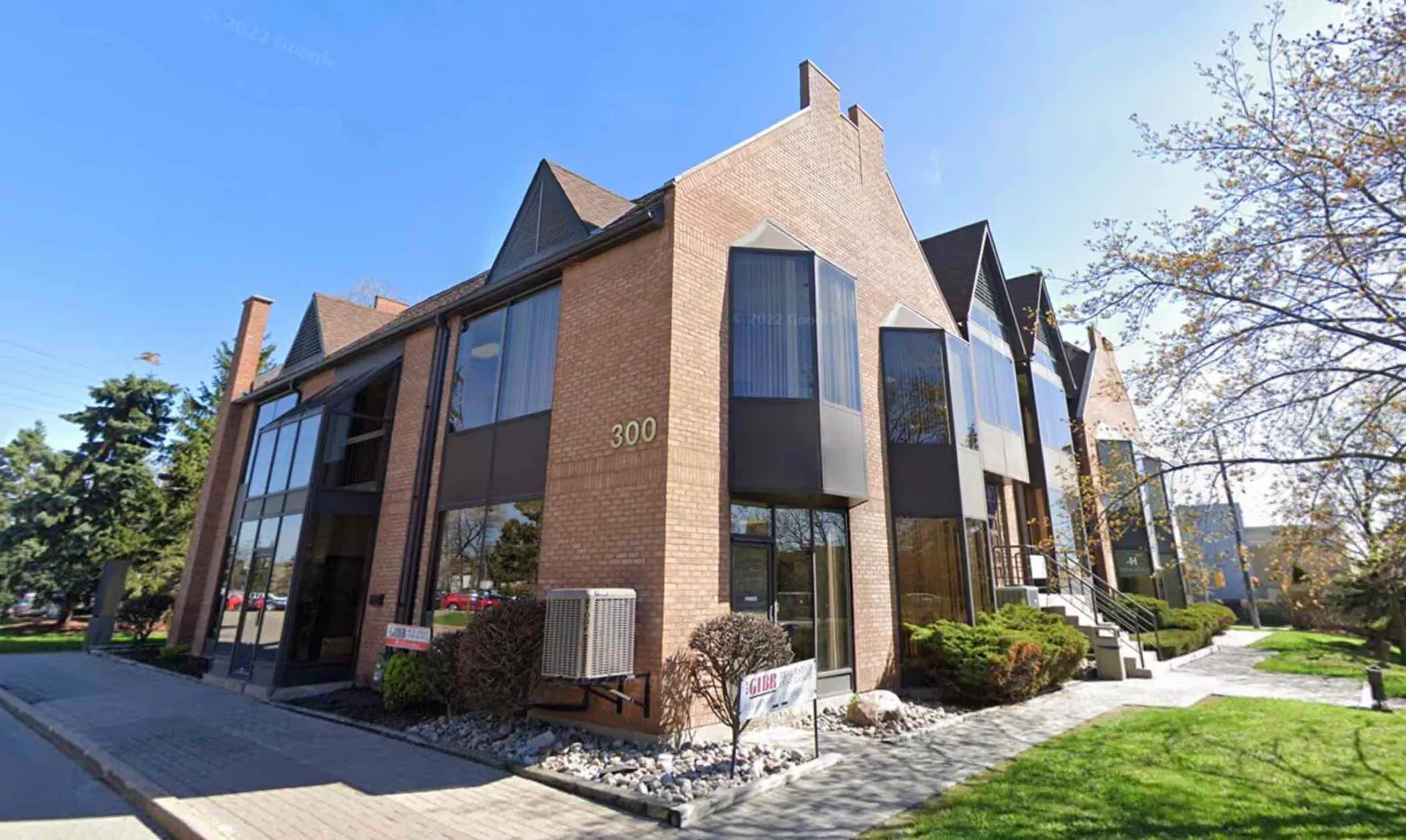 Modern brick office building with large windows and lawn