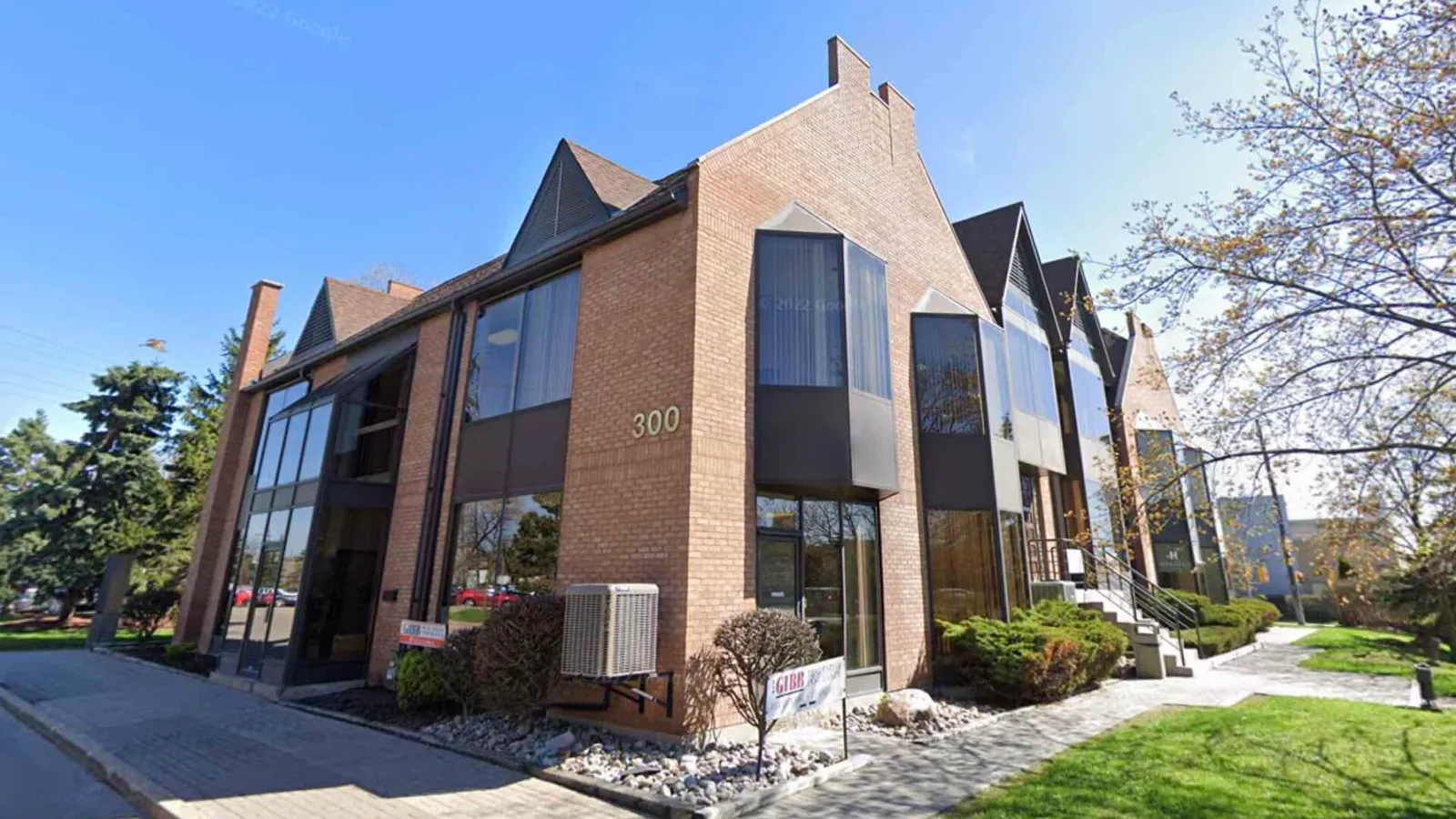 Modern brick office building with large windows and lawn